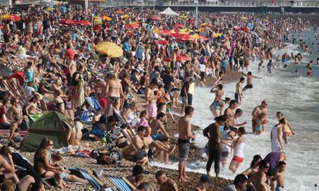 Over-consumption and over-population : Crowds of sun seekers fill the beach