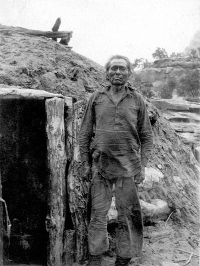 The spiritual home of the traditional Navajos was their enduring natural surroundings rather than their temporary hogan shelters. Nede Cloey (Nii'ditt'oii) at his hogan in Tsegi Canyon