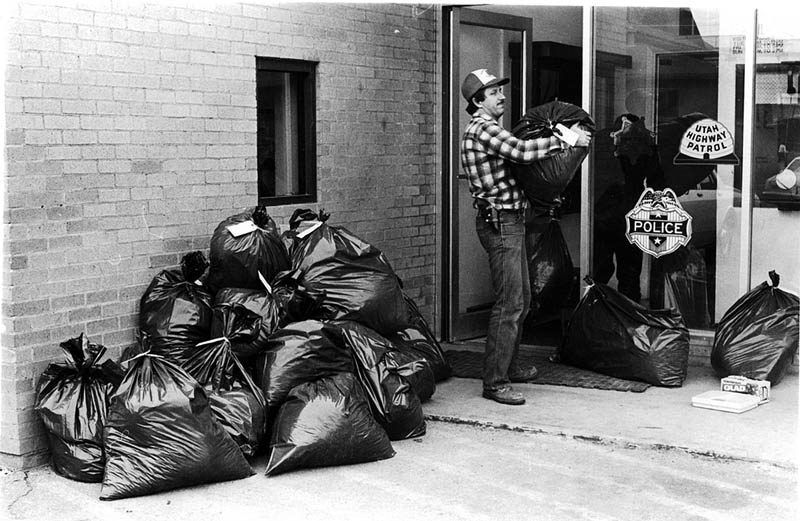 Deputy Roy Daughetee moves bags of pot into the sheriff's office. Photo by Bill Davis