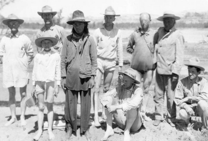 Stuart Young’s photo of the expedition members just after they forded the swollen San Juan River. Back row, left to right: Byron Cummings, William Blum, Neil Judd, Edgar Lee Hewett, Dogeye Begay. Front row: Malcolm Cummings, Randolph, Donald Beauregard, and John Wetherill.