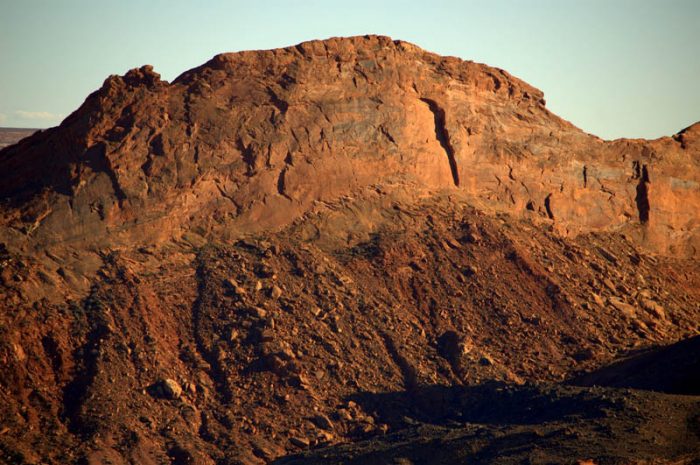 Figure 3. the “Mule Ear Wall”- a sheer wall in the Kayenta-Wingate sandstones; the “ear” stands seven hundred feet above the valley floor. (JR Lancaster photo)